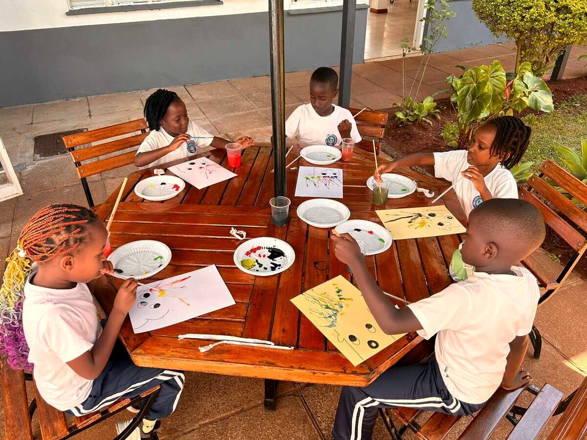 Children painting outdoors during an Early Years art class