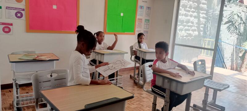 Students engaged in classroom learning with colourful bulletin boards