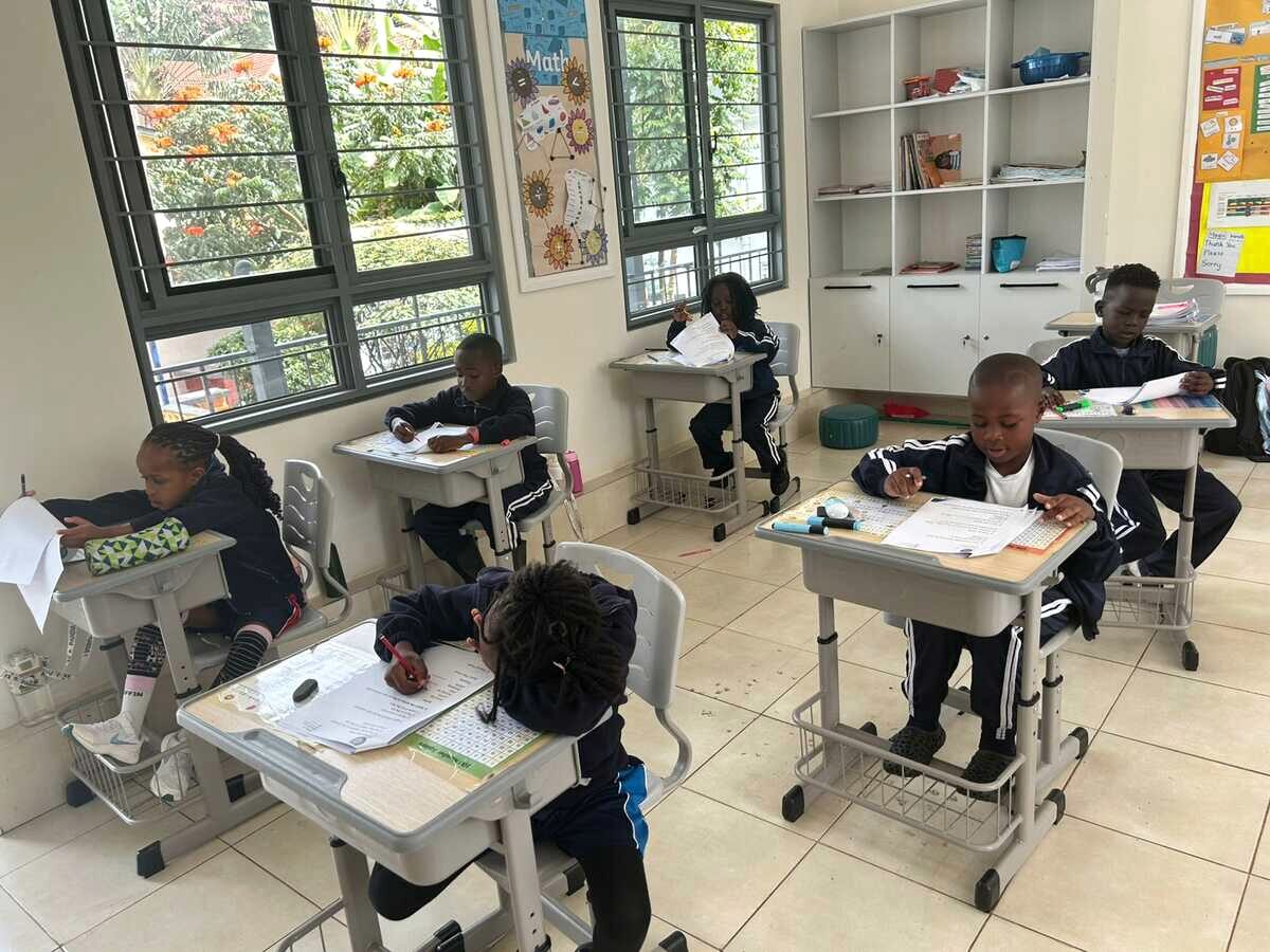 Students working at individual desks in a small classroom