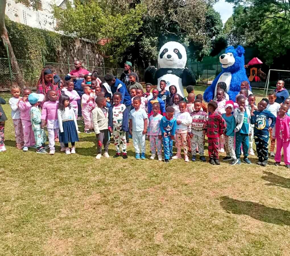 Students in pyjamas with mascots during a school event