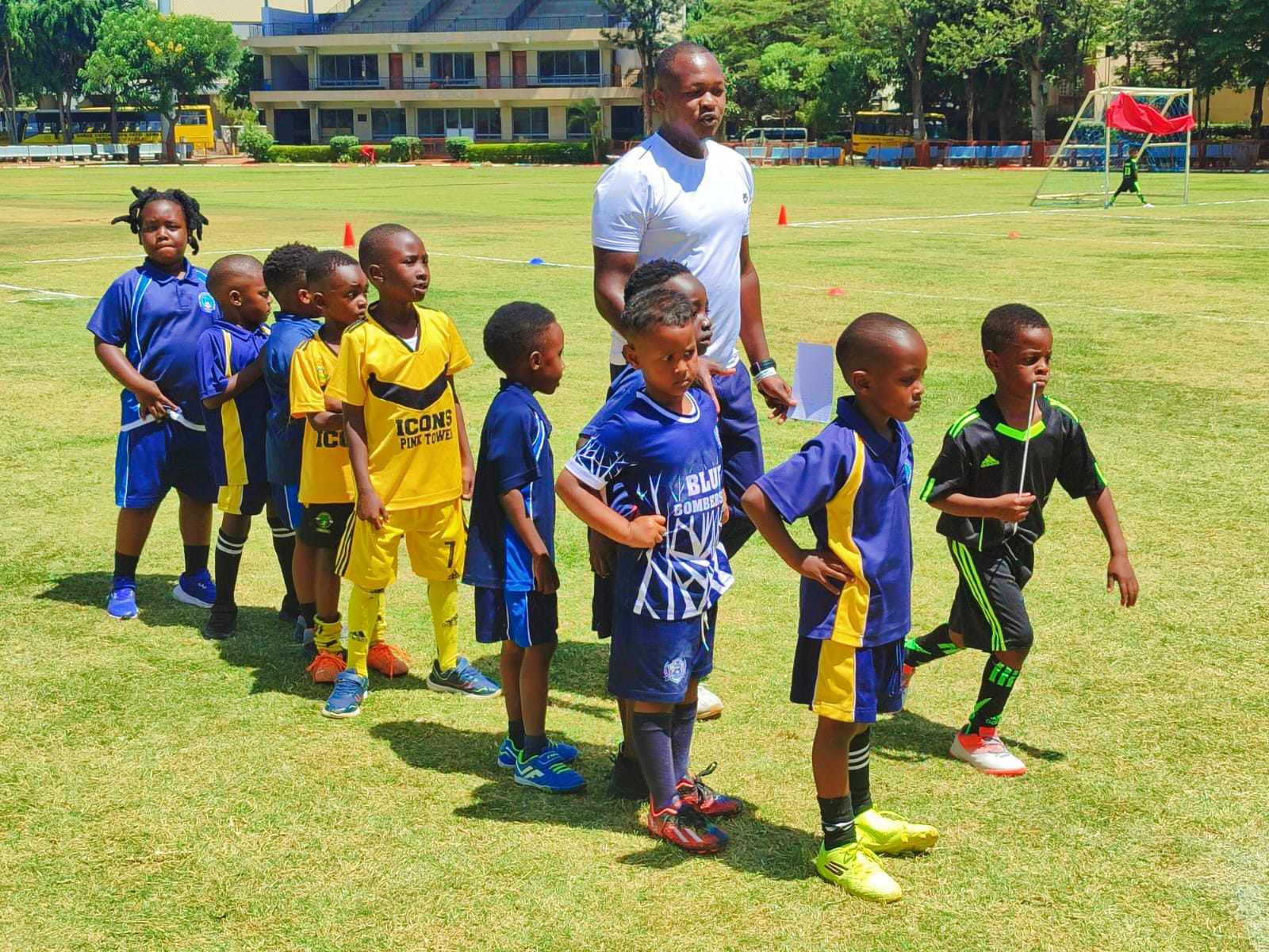 Pink Tower football team lining up with their coach at an inter-school tournament