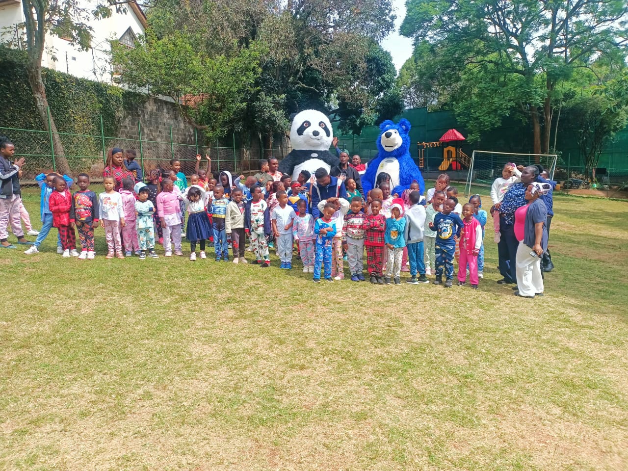Students in pyjamas with panda and bear mascots on the field