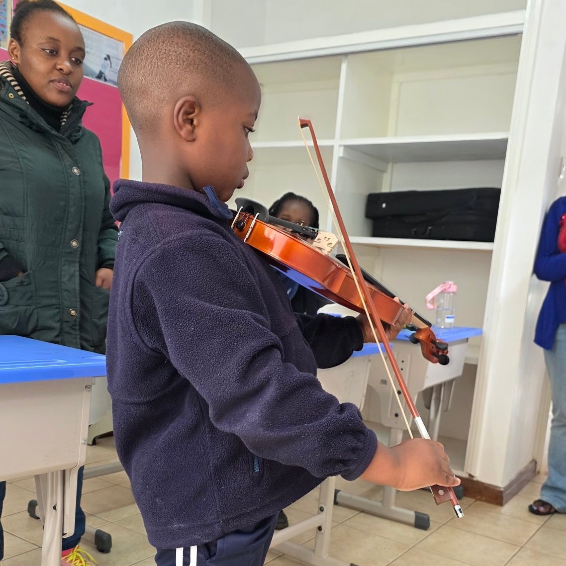 A young student learning violin in class