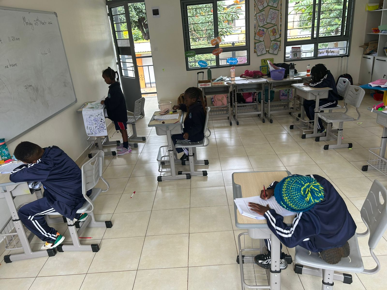 Students working at their desks in a bright classroom
